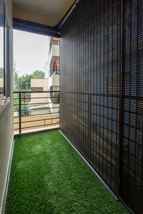 Balcony with artificial turf flooring and bamboo chick blinds