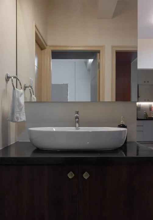 Vanity counter with a granite top, vessel basin and full-width mirror