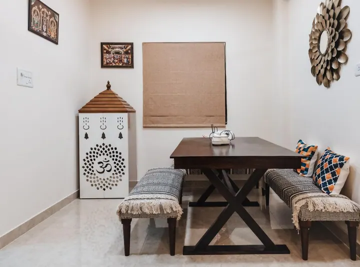 Wide view of a dining area with bench seating and a pooja unit alongside