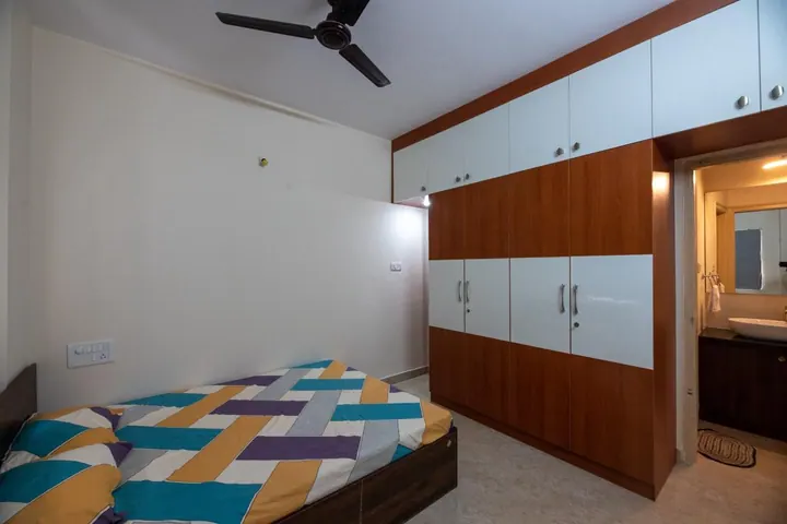 Guest bedroom with a two-tone wardrobe and attached bathroom