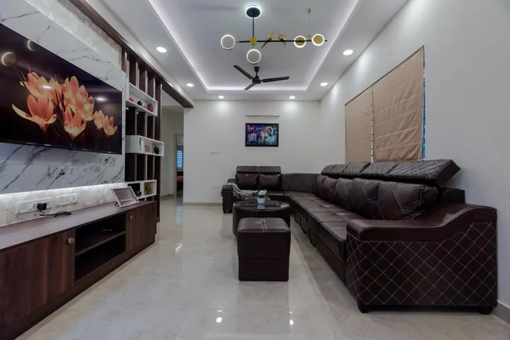 Living room with a leather sectional, cove lighting and a designer pendant