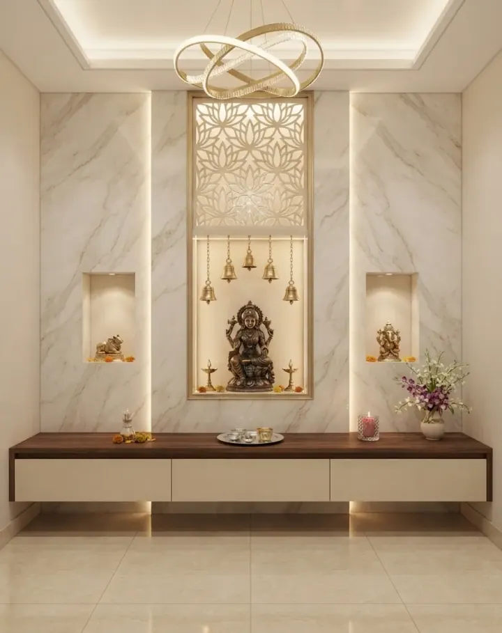 Pooja unit in marble with a backlit jaali panel and hanging bells