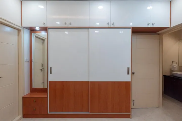 Sliding wardrobe in white gloss and wood laminate with an integrated dresser and loft storage